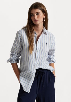 Lichtblauw en wit gestreepte button-up shirt, lange mouwen opgerold, met een marineblauw logo detail op de borst. Draag het met donkere joggingsbroek met trekkoord.