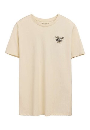 T-shirt beige à manches courtes avec col rond et petit logo graphique noir lisant « Teddy Smith » sur le côté gauche de la poitrine.