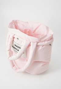 Sac fourre-tout en rose matelassé avec deux poignées douces, comportant une étiquette avec l'inscription "MADS NØRGÅRD COPENHAGUE." Design léger et arrondi.