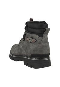 Botín de tobillo de ante gris con cuello acolchado negro, diseño con cordones, suela de goma y detalle de logo. Presenta costuras blancas y acentos texturizados.