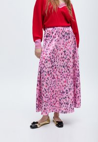 Růžová maxi sukně s leopardím vzorem v šedé, červené a černé barvě. Nosit s červeným topem a černými a zlatými balerínami. Hladká textilie.