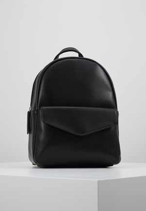 Sac à dos en cuir noir avec une forme arrondie, poche à rabat à l'avant, finition texturée et une poignée supérieure pour le transport.