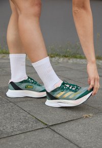 ADIZERO BOSTON 12 - Hardloopschoenen voor op de weg - collegiate green/matte gold/sandy pink