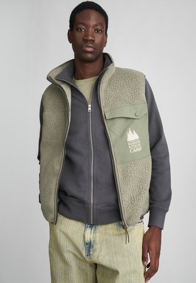 Fleece-gevoerde vest in groen en grijs, voorzien van een rits aan de voorkant, zijzakken en een bosafbeelding op de borst. Katoenmengsel laagjes eronder.