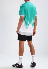 Lättvikts idrottströja i turkos, med en gradientstruktur som övergår till vitt, utrustad med tre axelränder och matchande svarta shorts.