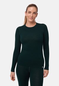 T-shirt à manches longues vert foncé en tissu doux, avec un col rond et une coupe ajustée, intégrant des coutures discrètes et une petite étiquette de logo.