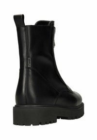 Zwarte leren enkellaars met een stevige zwarte rubberen zool. Voorzien van een ritssluiting en een lus om gemakkelijk aan te trekken. Glad oppervlak.