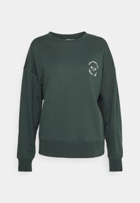 Sweatshirt vert en coton avec un col rond, des manches longues et des poignets côtelés. Présente un logo blanc sur la poitrine à gauche.