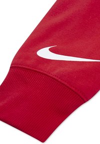 Maniche di felpa rossa con polsino a coste; presenta un logo Nike bianco ben visibile in design a swoosh sulla parte superiore. Tessuto morbido.