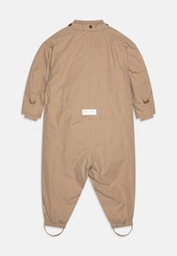 Brauner, leichter Overall mit langen Ärmeln, elastischen Bündchen und hohem Kragen. Verfügt über ein Etikett auf der Rückseite und kreisförmige Hardware-Akzente.