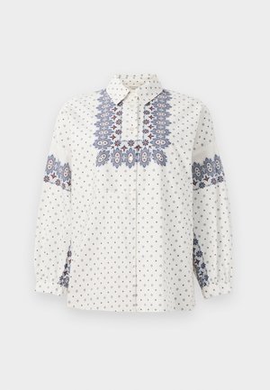 Chemise blanche avec broderie florale bleue et bordeaux sur le devant et les manches. Dotée d'un col à bouton et de longues manches froncées.