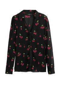 Blouse noire à manches longues, texture côtelée, présentant un motif de cerises en rouge et vert. Col classique avec une fermeture à boutons.