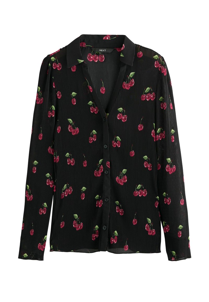 Blouse noire à manches longues, texture côtelée, présentant un motif de cerises en rouge et vert. Col classique avec une fermeture à boutons.