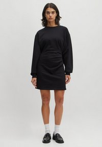 Schwarzes Sweatshirtkleid aus weichem Stoff, mit langen Ärmeln, lässiger Passform und einem Saum, der bis zur Mitte des Oberschenkels reicht. Einfaches Design ohne Muster.