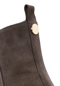 Gray suede ankle boot with a smooth finish, featuring a round gold hardware accent and a pull tab at the back for easier wear.