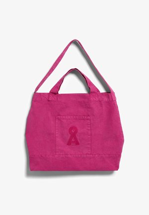 Felroze canvas draagtasje met korte handvatten, een lange schouderband en een voorvak met een gestikt sleutelgatvormig ontwerp.
