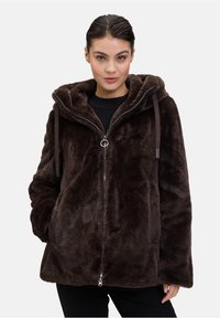 Giacca in finta pelliccia marrone con cappuccio, chiusura con zip e cordini. Presenta tasche laterali e una texture morbida e pelosa.