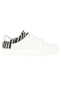 Zapatilla blanca con acentos de rayas negras y plateadas a lo largo del collar y el talón. Presenta una puntera redonda, cierre de cordones y suela de goma.