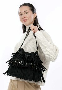 Borsa in suede nera con dettagli in frange e borchie dorate, dotata di chiusura con cordoncino e tracolla a doppio manico.