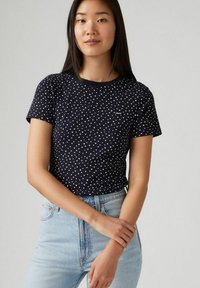 Marineblaue Baumwoll-T-Shirt mit weißen Punkten, kurzen Ärmeln und rundem Halsausschnitt. Verfügt über ein kleines Levi's-Logo auf der Brust.