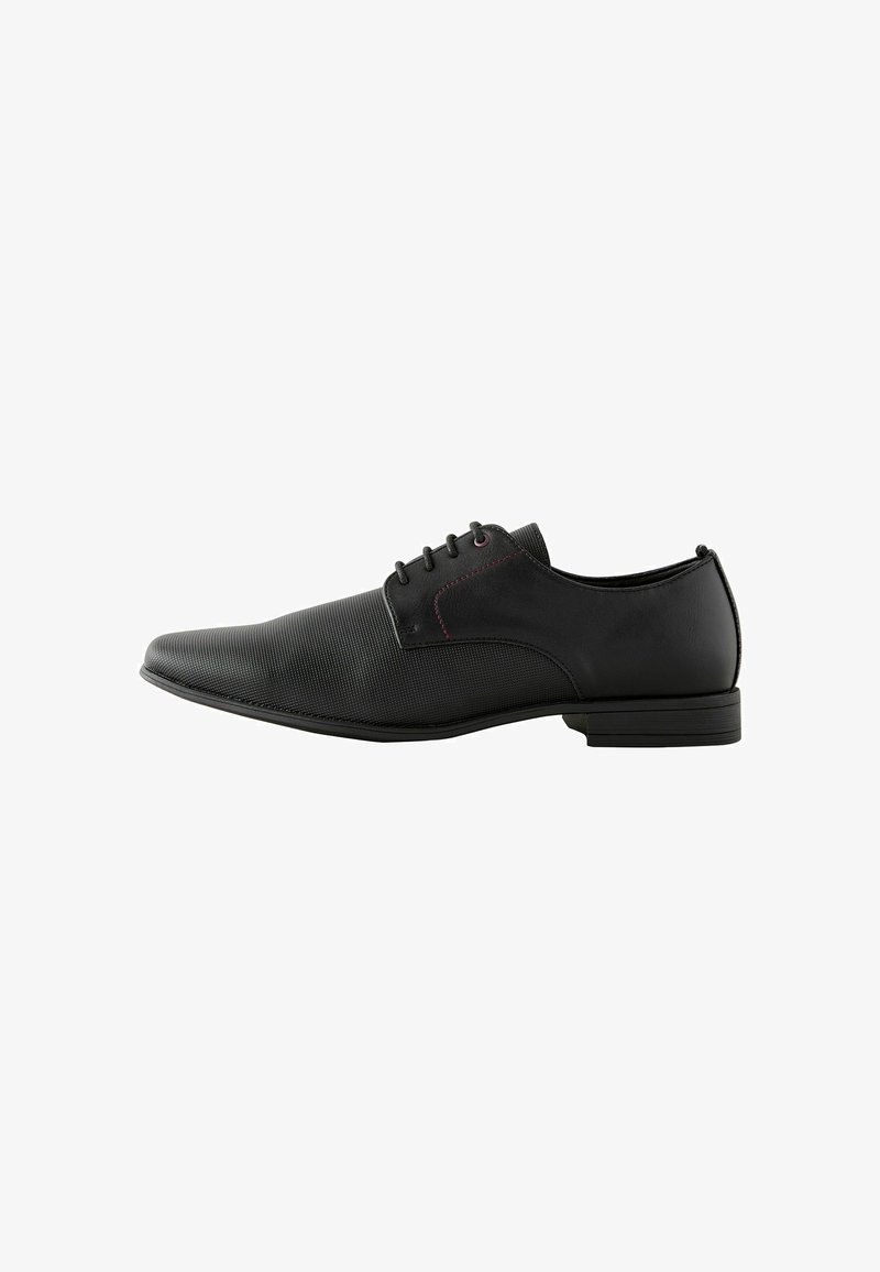 Zwarte veterschoenen met een bovenwerk van gladleer en een textuurpaneel. Beschikt over een slank ontwerp, platte zool en subtiele rode stikselaccenten.