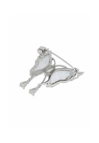 Silver butterfly-shaped brooch with white enamel details. Features a pin fastening and delicate chain accents. Glossy finish.