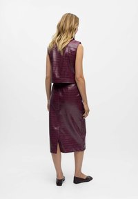 Paars nep-lederen cropped vest en midi rok set, met een gestructureerd krokodillenpatroon, een aansluitend ontwerp en een split aan de zijkant van de rok.