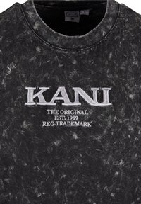 Sweat-shirt noir à motif marbre avec col rond. Présente un logo brodé "KANI" en blanc et le texte "THE ORIGINAL EST.1989 REG.TRADEMARK."