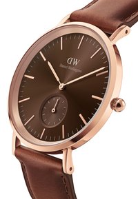 Brown leather strap watch featuring a rose gold case and a dark brown dial with minimalist hour markers and a sub-dial for seconds.