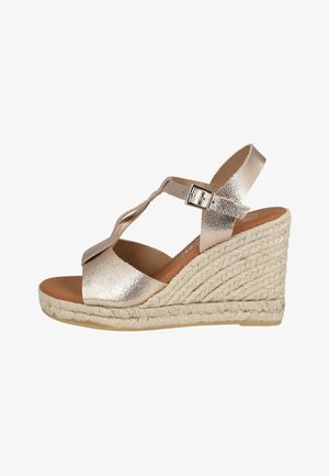 Sandalia de cuña con tiras de cuero metálico dorado, hebilla ajustable y suela de plataforma de cuerda trenzada.