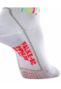 Chaussette de sport blanche ornée d'accents colorés en rouge et vert, avec une surface texturée et un design en maille respirante. Comprend un texte de marque.