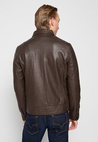 Giacca in pelle marrone con colletto, design aderente e texture liscia. Vista posteriore che mostra dettagli delle cuciture e bottoni ai polsini.