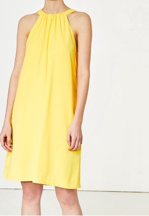 Robe sans manches jaune avec un col montant, des détails plissés et une coupe ample, fabriquée à partir d'un tissu léger. La longueur tombe au-dessus du genou.
