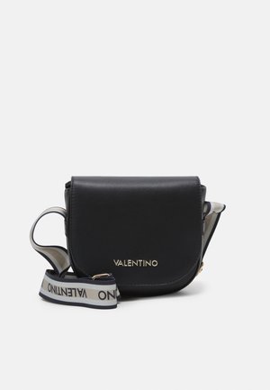 Sort Valentino crossbody taske med klap foran og hvidt justerbart stofrem med logo på en ensfarvet baggrund.