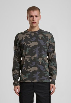Langærmet camouflage t-shirt med en blanding af mørkegrønne, lysebrune og blågrønnede mønstre på en sort bund. Blødt stof, crew neck design.