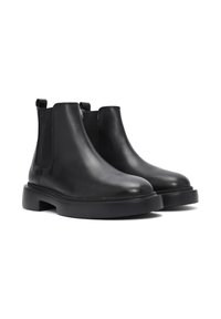 Botas de tobillo de cuero negro con paneles elásticos en los laterales, punteras redondeadas y una suela gruesa negra. Cuenta con lengüetas en la parte posterior para facilitar su uso.