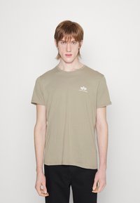 Khaki majica s kratkimi rokavi iz bombaža z okroglim izrezom, ki ima majhen natisnjen logotip na levem prsnem delu in sproščen kroj.