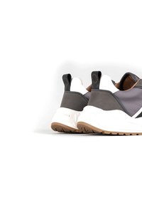 Sneakers atletici grigi e bianchi con una superficie texturizzata, supporto per la caviglia imbottito e suola in gomma con un battistrada a motivo.