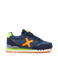 Zapatillas de deporte azul marino con acentos naranjas y un talón verde. Cuentan con una parte superior de textil, diseño de cordones y una suela de goma a rayas.