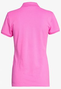 Rosa polo-tröja med klassisk krage och korta ärmar. Tillverkad av mjuk bomull, med en jämn textur och utan synliga mönster eller dekorationer.