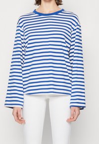 Långärmad tröja med rund halsringning i blå och vita horisontella ränder. Tillverkad av ett mjukt material med en avslappnad passform och breda ärmar.