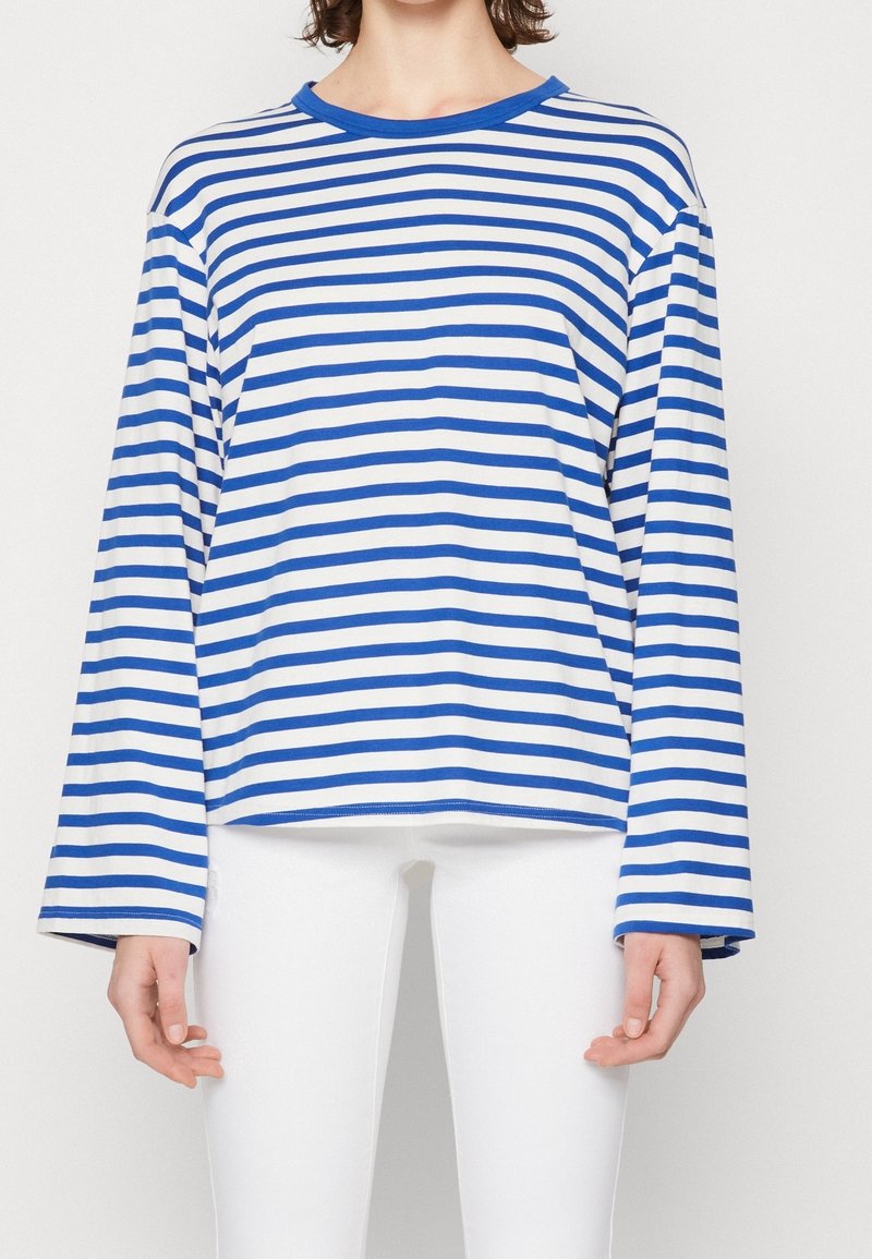 Långärmad tröja med rund halsringning i blå och vita horisontella ränder. Tillverkad av ett mjukt material med en avslappnad passform och breda ärmar.