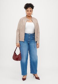 Μπεζ ψεύτικο δερμάτινο τζάκετ μπομπέρ, λευκό tank top, ανοιχτό μπλε ψηλόμεσα τζιν παντελόνια, μπορντό τσάντα και ταιριαστά ψηλά παπούτσια με μυτερή μύτη.