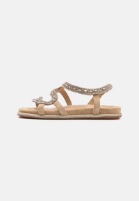 Beige suède sandalen met decoratieve metalen kralen, open teen ontwerp en enkelbandjes. Platte zool met een subtiele glansafwerking.