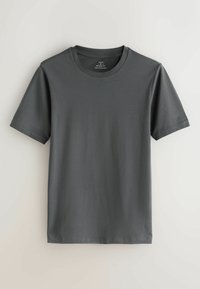 Vienkārša tumši pelēka īsroku T-krekla ar apaļu kakla izgriezumu ar „muskuļu piegriezuma” etiķeti, novietota guļus stāvoklī uz gaiša fona.