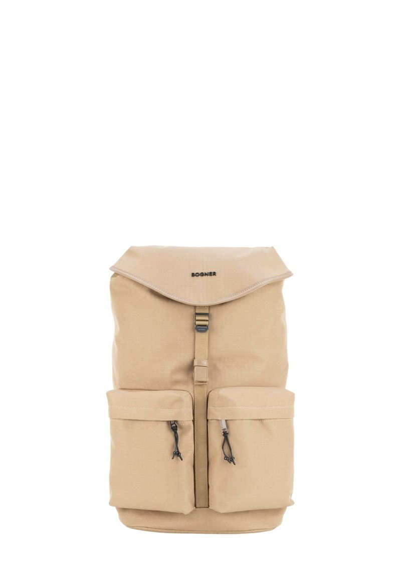 Bež nahrbtnik s pokrovom na zaponko, osrednjo sponko in dvema sprednjima žepoma z zadrgo, označen z logotipom "Bogner" na vrhu sredine.