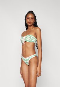 Grønn og rosa mønstrete bikini med stroppeløs topp som har en frontknute og matchende lavt liv-bunn; glatt, elastisk materiale.