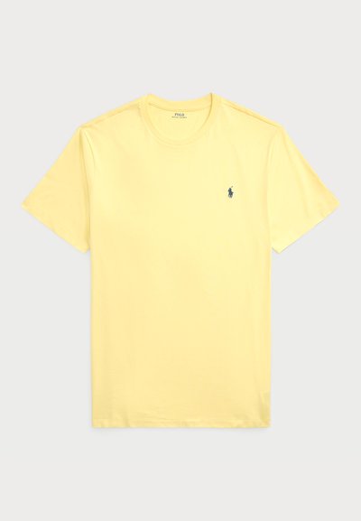 Dzeltena kokvilnas t-kreklu ar īsām piedurknēm, apaļo kakla izgriezumu un nelielu tumši zilu logotipu kreisajā krūtīs. Gluda tekstūra, bez rakstiem.