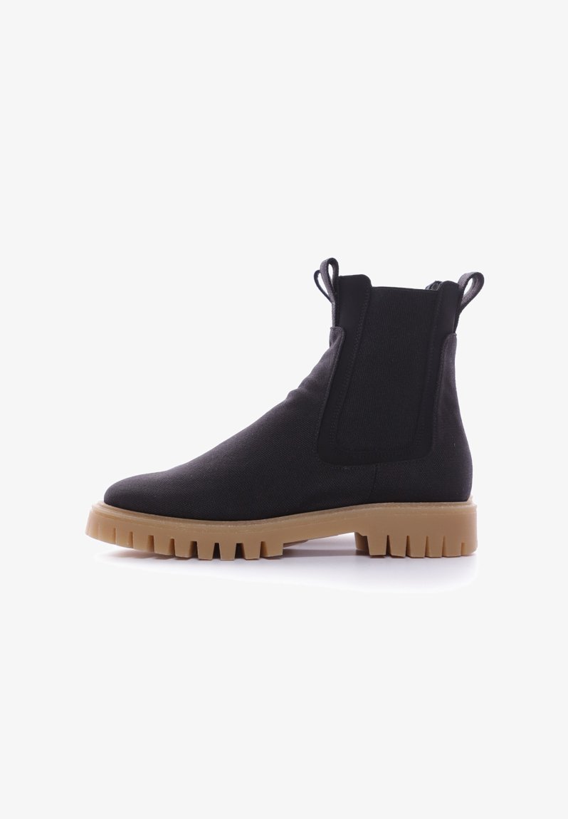 Botas de tobillo elásticas negras con parte superior de tejido texturizado, con dos tiradores, suela de goma gruesa y una forma esbelta y aerodinámica.
