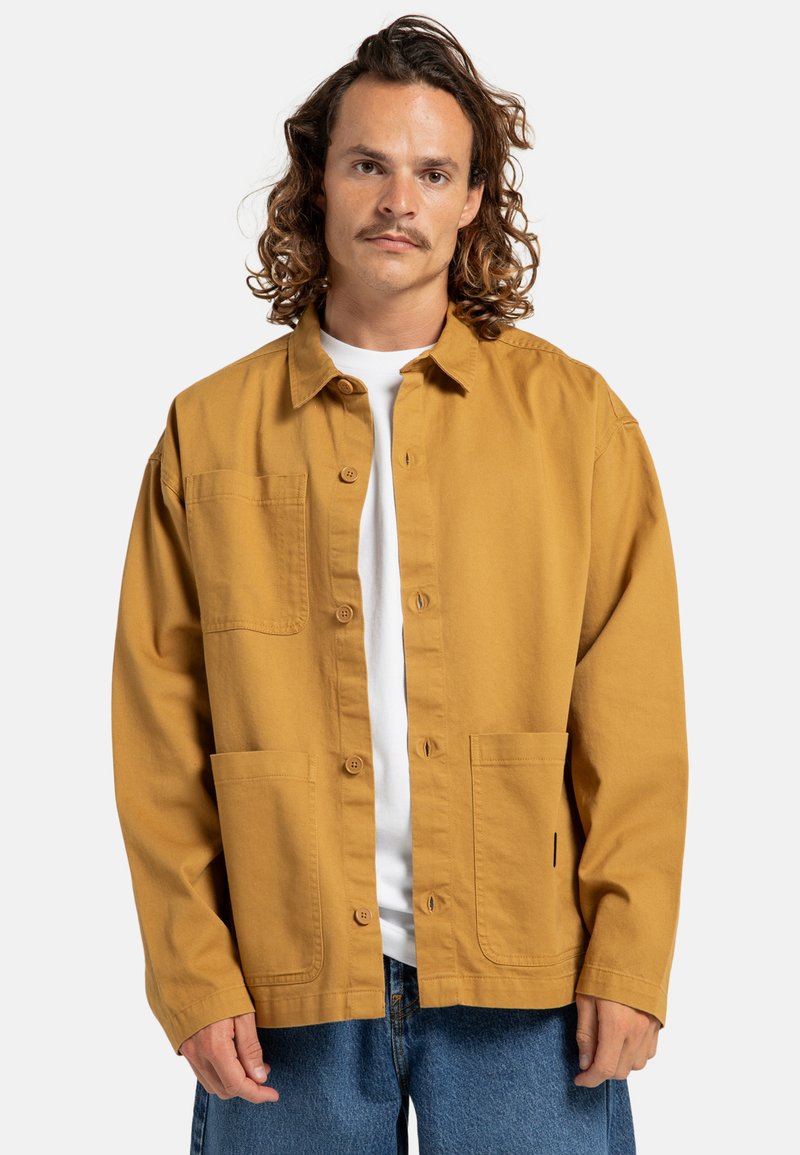 Lange mouwen, mosterdgele overhemdjas van katoen, met een knoopsluiting aan de voorkant, twee voorzakken en een relaxte pasvorm.